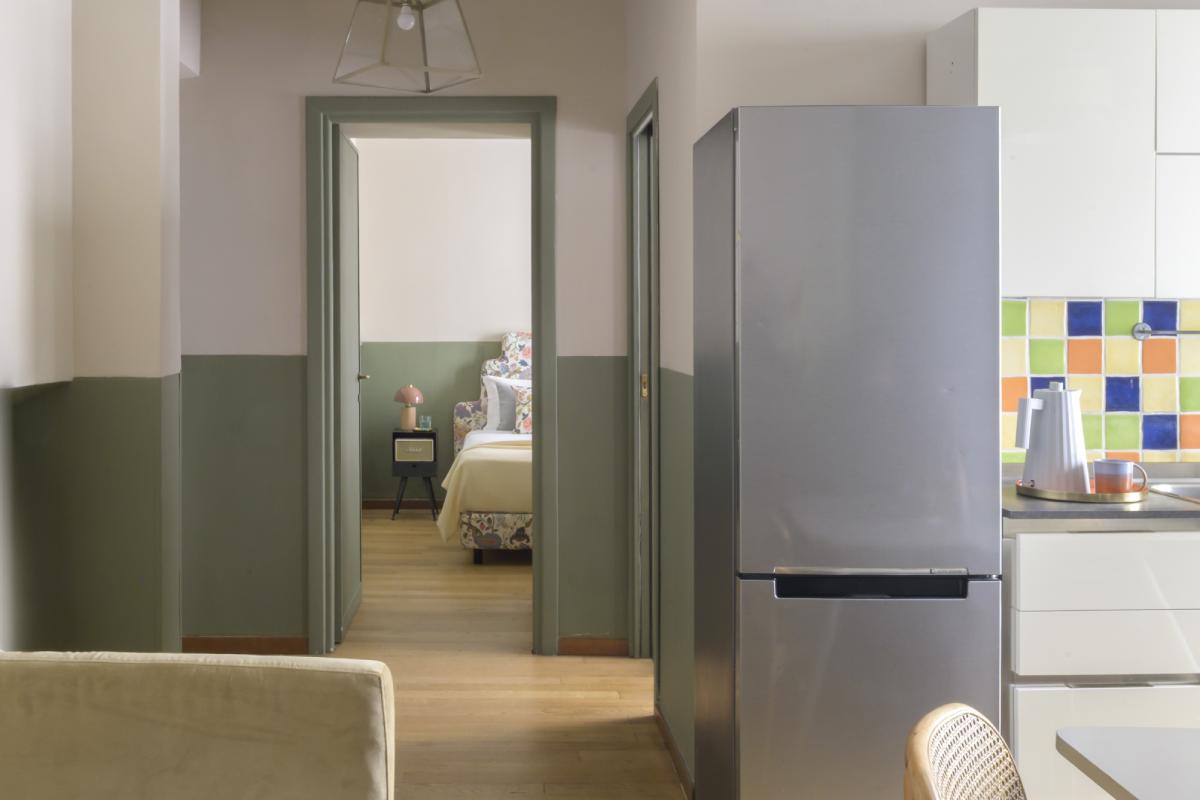 Apartment living area in Rome Monti district with blue sofa, coffee table, open wardrobe and bright dining area - Salotto Monti, BZAR hotels in Rome