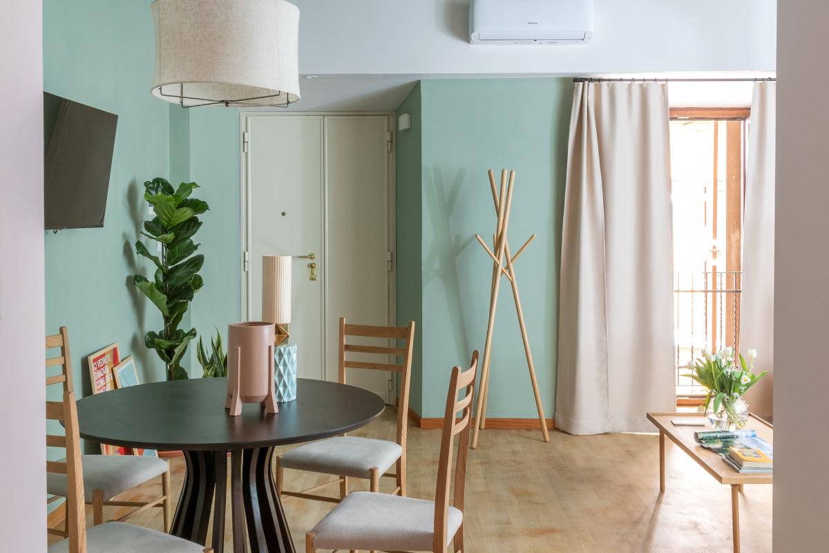 Two-bedroom apartment in Rome Monti district with living area, green sofa, colorful rug and fully equipped modern kitchen - Salotto Monti, BZAR hotels in Rome