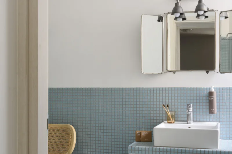 Bagno apartment nel rione Monti Roma con lavabo moderno, specchio vintage e piastrelle azzurre decorative - Salotto Monti, BZAR hotels a Roma
