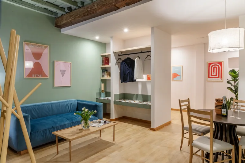 Zona living appartamento nel rione Monti Roma con divano blu, tavolino, guardaroba a vista e area pranzo luminosa - Salotto Monti, BZAR hotels a Roma