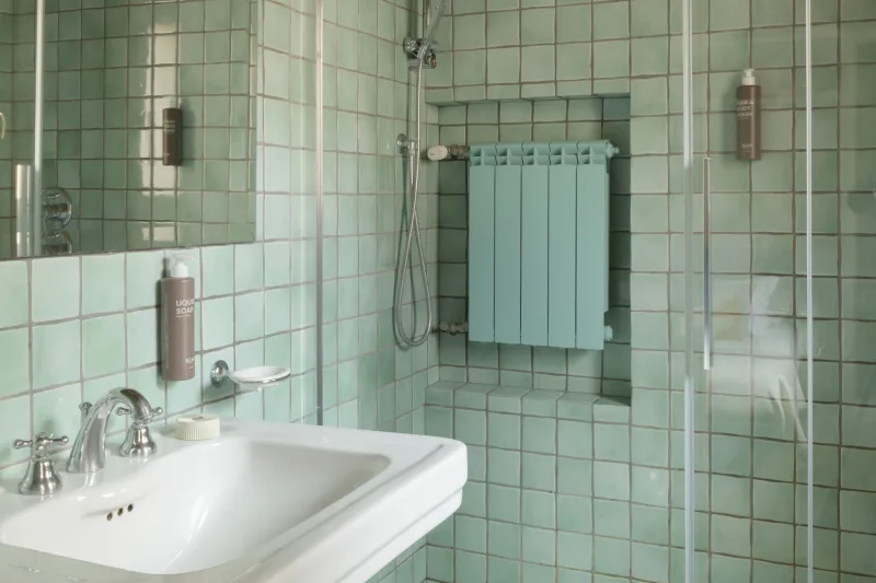 Bagno nel monolocale a Roma rione Monti con doccia in vetro, piastrelle verde acqua e lavabo classico luminoso - Salotto Monti, BZAR hotels a Roma