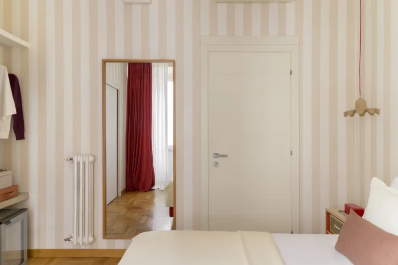 Elegant room in Rome Monti area with wall mirror, red curtains view, parquet floor and refined minimal design - Salotto Monti, BZAR hotels in Rome