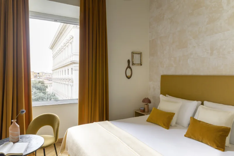 Room with view in Rome Monti district overlooking historic buildings, double bed, ochre cushions and natural light - Salotto Monti, BZAR hotels in Rome
