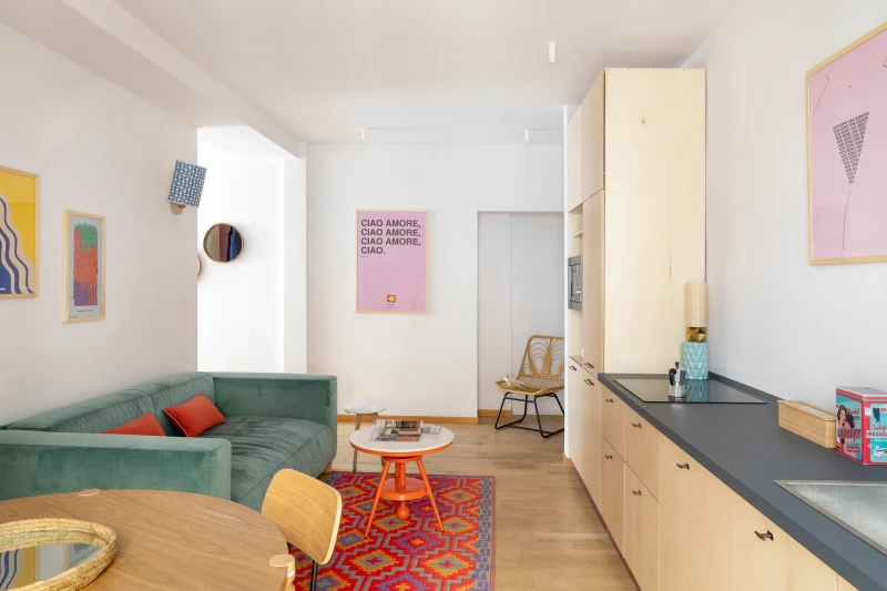 Appartamento trilocale nel rione Monti Roma con zona living, divano verde, tappeto colorato e cucina moderna attrezzata - Salotto Monti, BZAR hotels a Roma